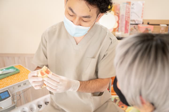入れ歯が外れやすので歯医者に相談する老人